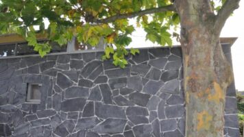 Steinplattenfassung an der Wand, Typ Lei Anthrazit. Noch nicht hinzugefügt und gereinigt.